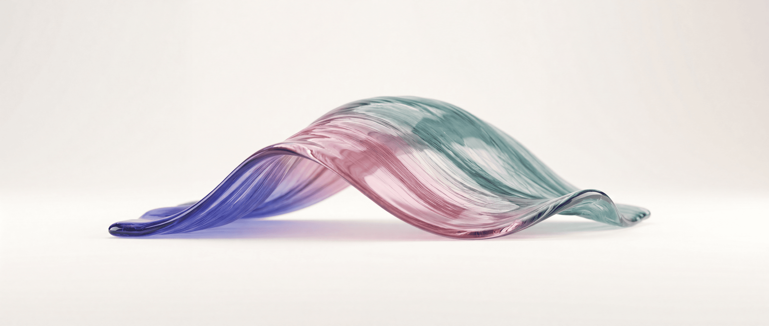 A sculptural wave of glass shifting from indigo through rose to teal on a warm off-white surface
